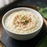 A small bowl of creamy rice kheer with almonds and pistachios